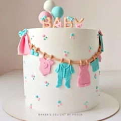 A lovely baby shower cake with a clothesline of tiny, handcrafted fondant baby clothes in pink and blue. This design is perfect for a gender-neutral celebration, topped with the word "BABY" and cute balloons.