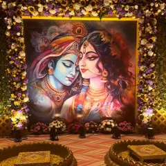 A closer view of the divine Radha Krishna backdrop. The rich colors of the painting are complemented by the vibrant floral frame, creating a perfect setting for a sacred Haldi function.