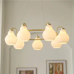 Inspired by the soft glow of the moon, this chandelier features frosted glass globes on a circular golden frame. It provides a warm and calming light, perfect for creating an inviting atmosphere in a bedroom or intimate dining area.