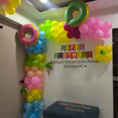 A fun and colorful birthday corner decoration. This arrangement uses a variety of bright colors and donut-shaped foil balloons for a playful look.