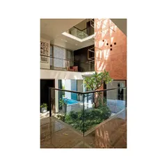 An internal courtyard in the Notan Home, designed as a private oasis that brings light, air, and nature into the center of the house. This multi-level view shows the interplay between the water body, the indoor planter with a frangipani tree, and the living spaces above, creating a constant visual connection across the home.