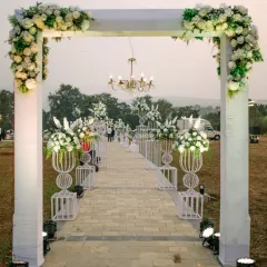 A grand welcome into a white wonderland. This stunning entrance features a series of white arches adorned with florals and chandeliers, creating a breathtaking pathway for guests.