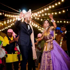The bride and groom dancing their hearts out during the Baraat. We focus on capturing the movement and happiness of the celebration under the festive lights.