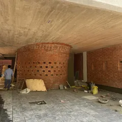 The curved brick structure at the base of the Waterfall house, seen here during construction. This 'brick globule' is designed to be a sculptural element that glows like a lantern at night.