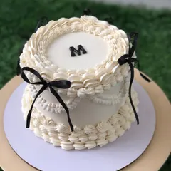 "Vintage Minimalism" in black and white. This cake features classic Lambeth piping with elegant black ribbon details for a chic, modern twist.