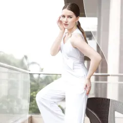 A full-length shot of the model in the white jumpsuit, emphasizing the garment's silhouette and modern design.