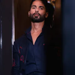 A moody, atmospheric shot of Shahid Kapoor. The subtle red embroidery on his dark suit adds a unique and personal touch.