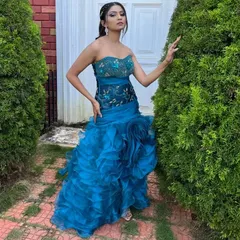 This strapless blue ruffled bodycon gown is a modern and stylish choice. The tiered ruffles on the skirt add texture and movement, making it a unique piece for any event.