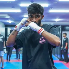 The intensity and focus of a boxer. With hands wrapped and in a ready stance, this fighter shows the concentration required during our boxing training sessions.