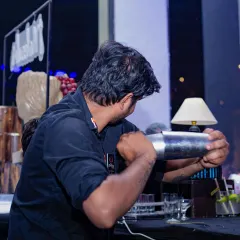 A bartender meticulously shaking a cocktail. This shot captures the focus and skill that goes into crafting each and every drink for your guests.