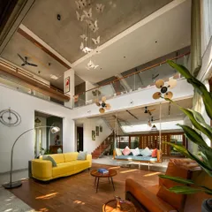 The double-height living area is the heart of the home, designed as an open pavilion. With its tall wooden doors fully opened, the space becomes an extension of the garden, blurring the line between inside and out.