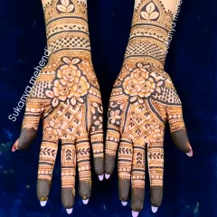 A gorgeous engagement mehendi with bold floral patterns as the centerpiece. The dark fingertips and delicate net patterns on the fingers create a beautiful contrast.