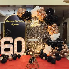 Milestone birthdays deserve to be grand. We designed this stylish black, gold, and white theme for a 60th birthday celebration at home, transforming the space with a shimmer wall, marquee lights, and a sophisticated balloon arrangement.