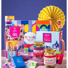 A colorful gift hamper from Harajuku Tokyo Cafe, featuring macarons, cookies, and other treats, styled with bright, playful props.