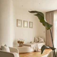 We transformed a structural column into a design opportunity by creating a curved wall with two functional alcoves. This larger niche houses an inviting daybed, perfect for unwinding with a book, adding an element of softness and sophisticated comfort to the master bedroom.