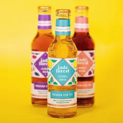 A vibrant shot of Jade Forest's premium iced tea collection. The bright yellow background and clear focus on the central bottle make this a perfect hero image for their website.