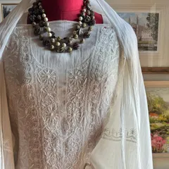 A close-up of the yoke of our off-white Chikankari suit, showing the intricate floral and paisley motifs that are central to this traditional craft.