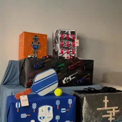 A full view of the themed birthday gifts I curated for Akash Ambani. The collection includes a pickleball-themed box, an Arsenal football tribute, a robot-inspired design, and a box decorated with miniature cars.
