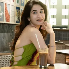 A candid moment in a cafe. The model is enjoying a cold coffee, creating a relatable and authentic lifestyle portrait that feels natural and unposed.