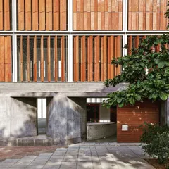 This facade features operable wooden louvers and concrete forms, allowing users to modulate sunlight and airflow. This is a low-tech, high-impact strategy I use to create comfortable and energy-efficient buildings.
