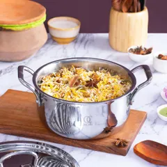 A lifestyle shot for Omichef's stainless steel cookware, featuring a freshly made biryani. The styling uses authentic ingredients like star anise to create an aromatic and tempting scene, highlighting the pot's capacity and quality for cooking traditional Indian dishes.