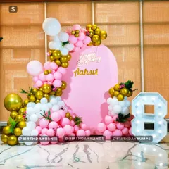 The final look of our chic pink, white, and gold balloon decor, complete with a custom name backdrop and a large light-up number '8'.