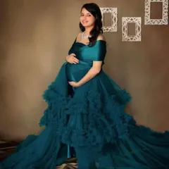 A stunning teal ruffled gown photographed in the studio. The rich color and cascading layers of tulle create a luxurious and elegant look that beautifully frames the baby bump.