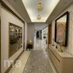 This foyer uses a mix of elements to create a grand entrance. We combined tinted, bevelled mirrors with textured wallpaper, a patterned tile inlay in the flooring, and a sleek console table to create layers of interest.