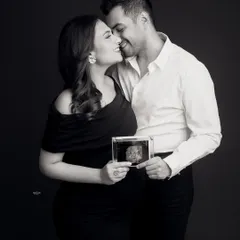 A beautiful beginning. This couple holds up their baby's sonogram picture, a wonderfully creative and emotional way to announce their pregnancy in a classic black and white portrait.