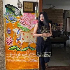 Here I am with a custom Pichwai-style mural I painted right at the entrance of my home. This piece, featuring a decorated cow and vibrant lotuses, shows how I adapt traditional Indian art to create a warm and personal welcome.