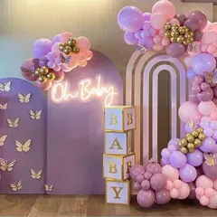 This pastel baby shower decoration is one of my most requested styles. It features custom-built lavender arched panels with delicate butterfly accents, an "Oh Baby" neon sign, and a stunning organic balloon garland in shades of lilac, pink, and gold. The stacked "BABY" blocks complete this elegant and modern photo-ready backdrop.