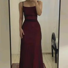 A client's mirror selfie showcasing the simple elegance of this maroon spaghetti strap gown. The clean lines and perfect fit are central to my design philosophy.
