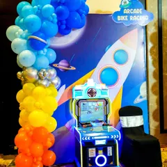 Our arcade bike racing game, set against a custom space-themed backdrop, shows how we integrate games into your party's decor.