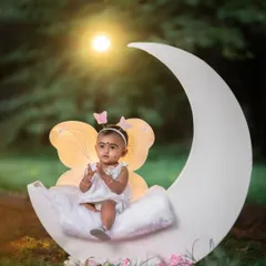 We create enchanting scenes for our fairy-themed shoots. Using props like this moon and soft lighting, we can turn a simple park into a whimsical wonderland for your child.