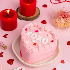 A sweet and simple heart-shaped bento cake for Valentine's Day. The pink frosting, "XOXO" lettering, and surrounding heart confetti make this a perfectly romantic and trendy shot.