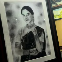 A finished and framed realistic portrait of a woman in traditional attire. The framing adds a final touch of elegance to the detailed charcoal and graphite artwork.