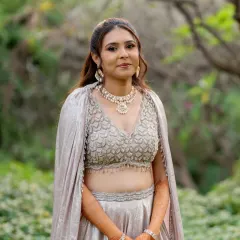 A beautiful outdoor portrait of Darshali. Her makeup is natural and timeless, ensuring she looks effortlessly beautiful in her stunning silver reception outfit.