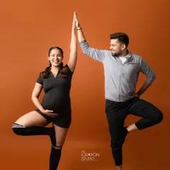 A high five for teamwork. This fun pose from a sporty themed maternity shoot celebrates the couple as partners in their journey to parenthood.