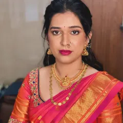 The makeup is clean and defined, perfectly complementing her traditional pink and orange silk saree.