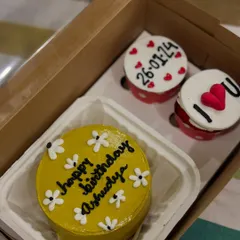 A cheerful yellow birthday bento and cupcake hamper. The cupcakes are decorated with the date and a simple "I love you" message.