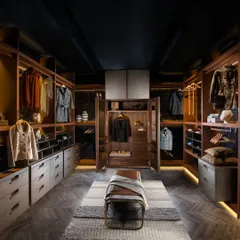The same walk-in closet, shown here with its central cupboard doors open to reveal additional, dedicated storage. This demonstrates how we provide versatile solutions to accommodate everything from long coats to folded items within a single, elegant design.