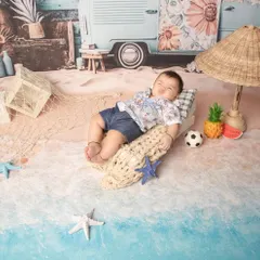 I create detailed, imaginative studio setups to bring any theme to life. For this sitter session, we created a mini beach scene complete with a tiny van and surfboard, making for a unique and playful portrait.