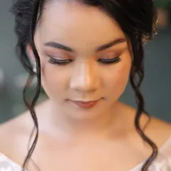 A close-up of the angelic makeup for a Catholic bride. The focus is on luminous skin, soft brown and gold eyeshadow, and a natural lip color, creating a look of timeless elegance.
