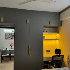 This design cleverly integrates a study nook into a large wardrobe. The open shelves are backlit, creating a perfect spot for work or study.