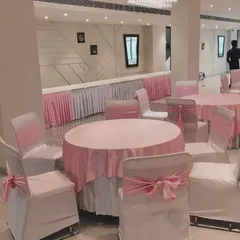 A key part of my service is creating a visually appealing dining environment. This setup for a corporate event or private party features a clean pink and white color scheme, with neatly arranged round tables and dedicated buffet stations in the background. My team handles all the details of the banquet setup.