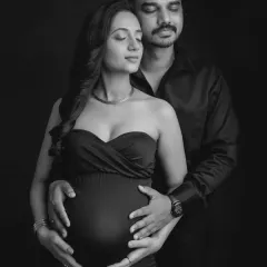 A powerful and serene black and white portrait. With both your hands on the bump, this image symbolizes your shared journey and the love that surrounds your growing baby.