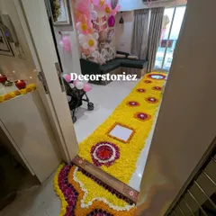 The view from the doorway of the welcome home decor. The intricate flower rangoli at the entrance sets a traditional and celebratory tone for the baby's arrival.