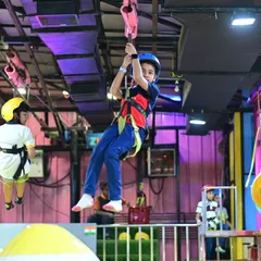 Another angle of our thrilling zip-line, showing a young adventurer soaring through the air. It's an exciting experience they'll be talking about long after the party is over.