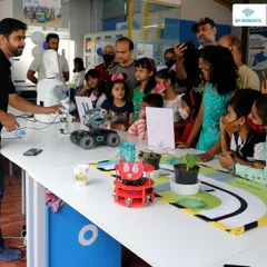 An instructor demonstrates a robot's capabilities to an excited group of kids and parents at a RoboExpo. These events are a great way for the community to experience the magic of robotics firsthand.