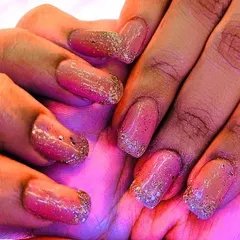 A soft and pretty look using a pink gel base with a delicate gold glitter fade on the tips. This style of ombre glitter nails is a popular choice for adding a touch of sparkle without being too bold.